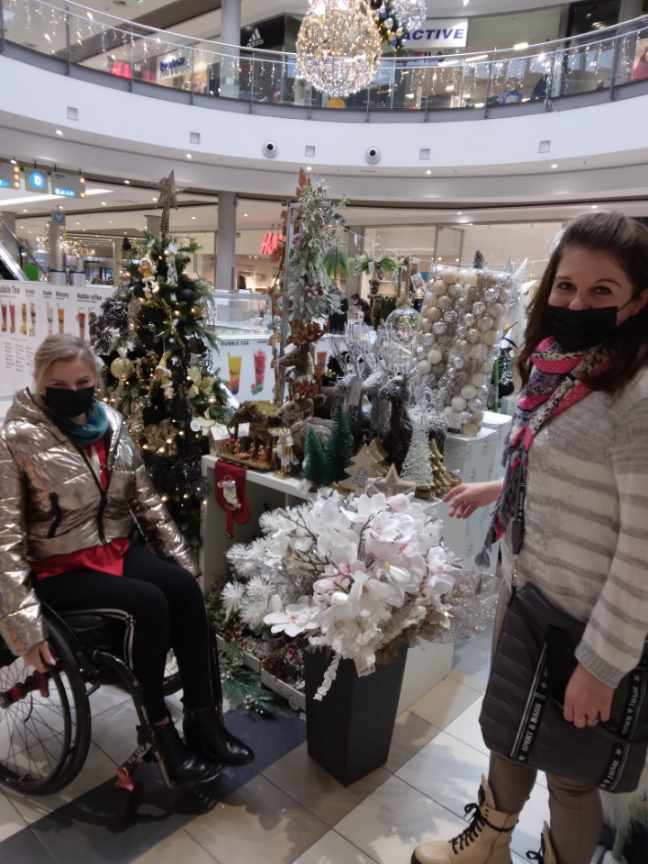 OSOBA Z ASYSTENTEM NA ZAKUPACH W ŚWIATECZNEJ SCENERII