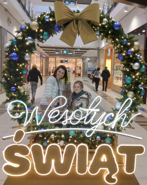 OSOBA Z ASYSTENTEM NA ZAKUPACH W ŚWIATECZNEJ SCENERII