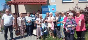 grupa seniorów z opaskami życia przed budynkiem 